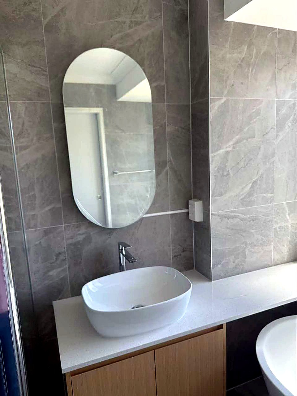 Bathroom with oval mirror and stone basin